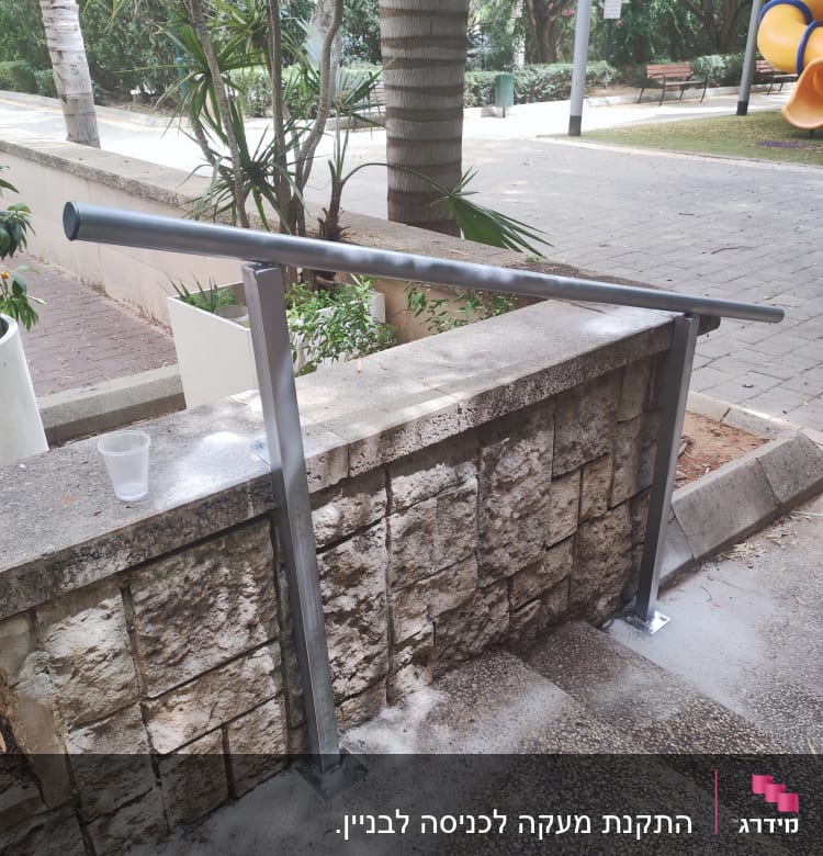 מעקה מתכת מותקן על מדרגות אבן